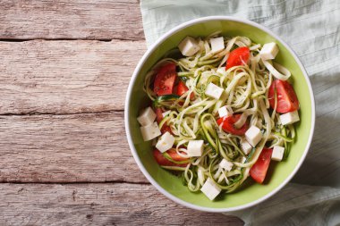 zucchini pasta with feta cheese and tomatoes horizontal top view