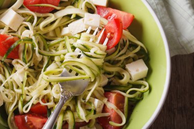 zucchini pasta with feta and tomatoes macro. horizontal top view