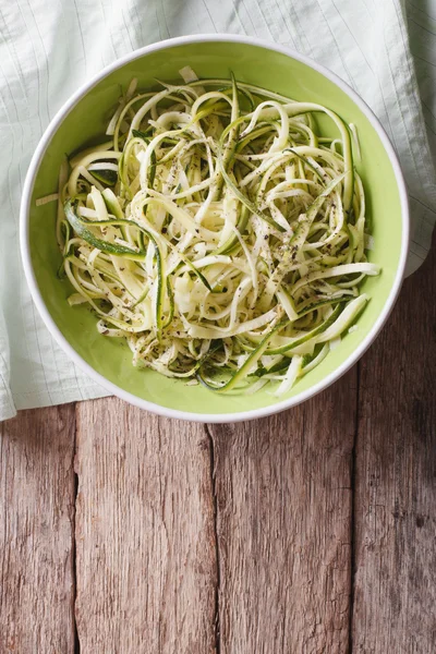 Useful raw zucchini pasta in a bowl close up. vertical top view — Φωτογραφία Αρχείου