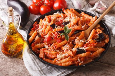 Penne with eggplant and tomatoes closeup and ingredients. horizo