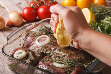 Squeezing lemon juice in the marinade for meat. horizontal