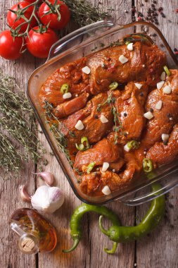 Meat in red marinade with spices close up in a bowl. vertical to