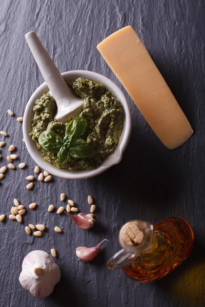 Traditional pesto sauce in a mortar and ingredients. vertical to — Zdjęcie stockowe