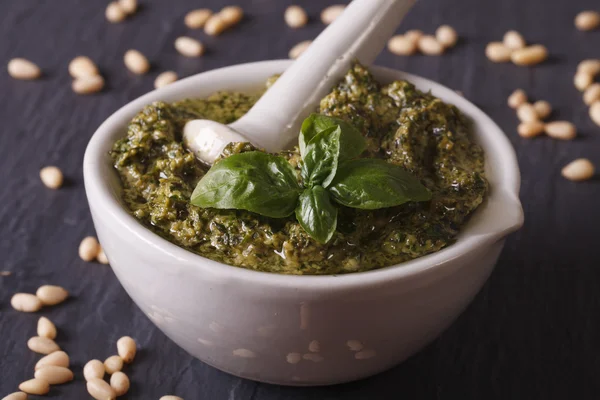 Pesto verde italiano en un primer plano de mortero sobre la mesa. horizonta — Foto de Stock