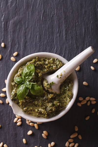 Pesto verde italiano em um grande plano de morteiro. vista superior vertical — Fotografia de Stock