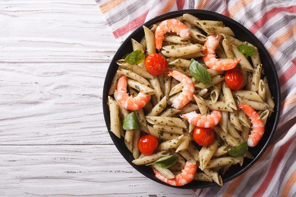 Pasta with shrimp, tomato and pesto sauce. horizontal top view — Stock Photo, Image