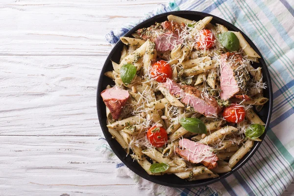 Nudeln mit Fleisch, Parmesan, Tomaten und Pesto. horizontale Spitze vi — Stockfoto