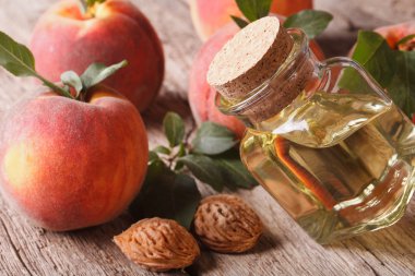 kokulu yağ şeftali çukurlarının şişe closeup masanın üzerinde. h