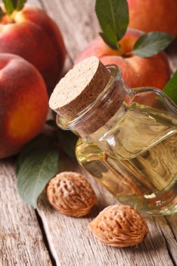 Masaya bir şişe yakın çekim yararlı şeftali çukurlar yağda. vertic