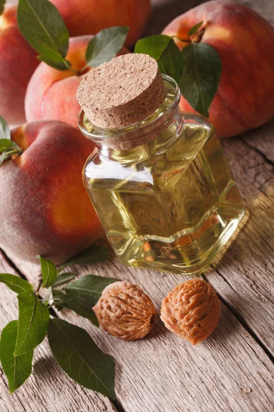 Natuurlijke verse perzik olie in een glazen fles close-up. verticale — Stockfoto