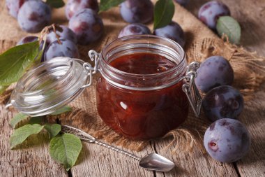 Sweet plum marmalade in a glass jar on the table close-up