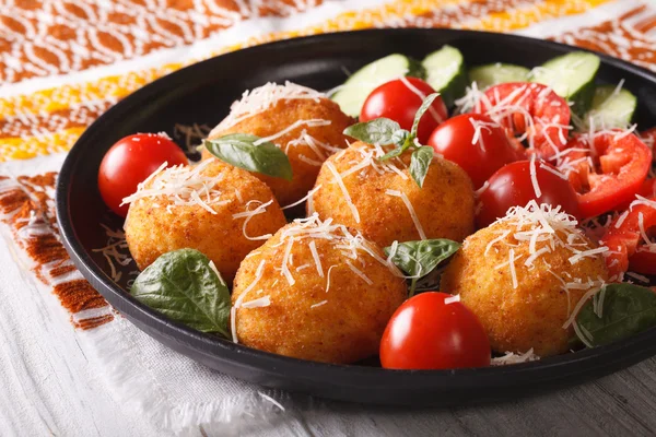 Fried rice balls and fresh vegetable salad on a plate. horizonta — 图库照片