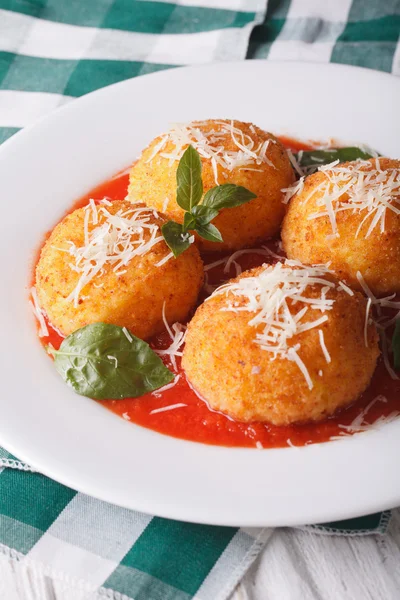 Delicious rice balls in tomato sauce on a plate close-up. vertic — Stock Photo, Image