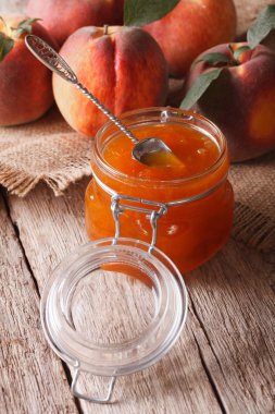 Fresh homemade peach jam in a glass jar close-up. vertical