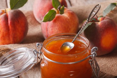 Fresh peach jam in a glass jar macro. horizontal