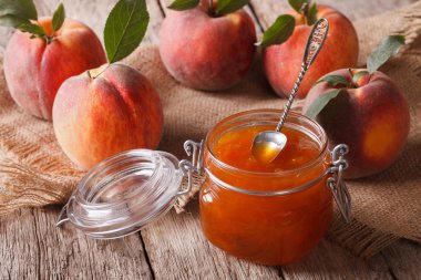 Fresh homemade peach jam in a glass jar close-up. Horizontal