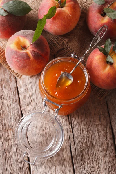 Fresh peach jam in a glass jar close up. vertical top view — Stockfoto