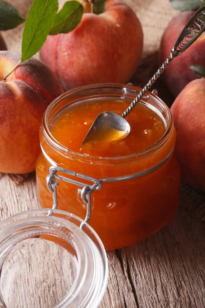 Peach jam in a glass jar close up on the table. Vertical — Stockfoto