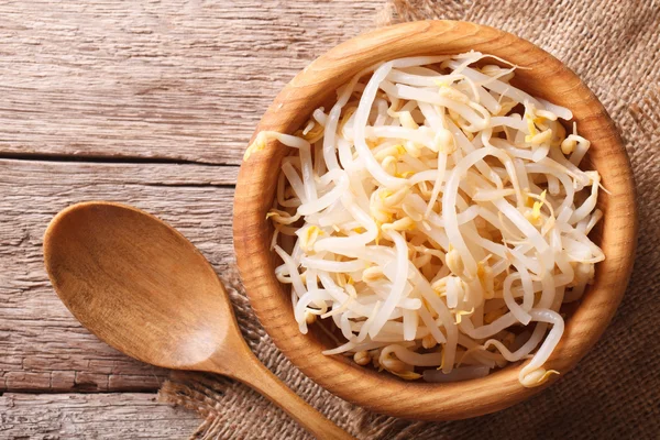 sprouts of mung beans in a wooden bowl. horizontal top view