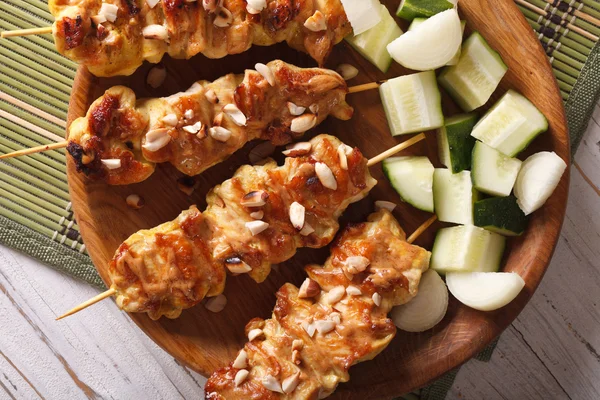 Chicken satay sprinkled with peanuts close-up. horizontal top vi — Stock Photo, Image