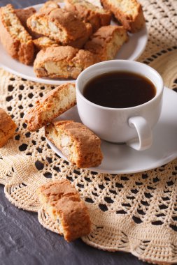 Koyu bir kahve ve bir tablo yakın çekim üzerinde bademli kurabiyeler. Verti