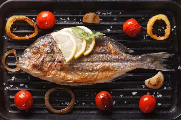 Dorado fish with vegetables closeup on the grill. horizontal top — Stock Photo, Image