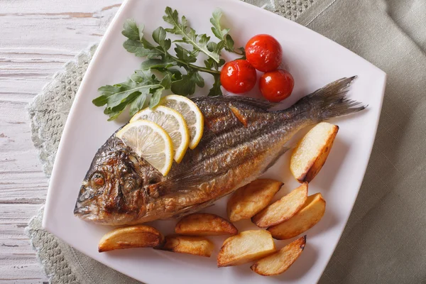 Pesce dorado alla griglia con patate fritte primo piano. piano orizzontale — Foto Stock