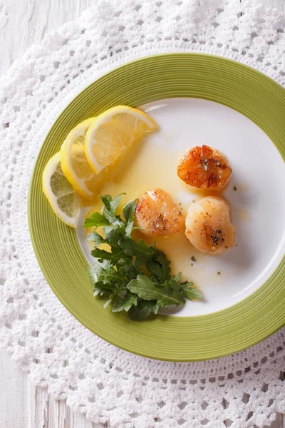 Fried scallops with sauce and lemon on a plate. vertical top vie — Stock Photo, Image