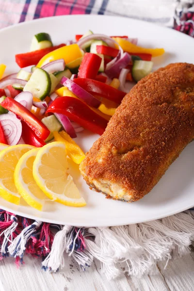 Смажена риба зі свіжим овочевим салатом на тарілці крупним планом. Вертьє — стокове фото