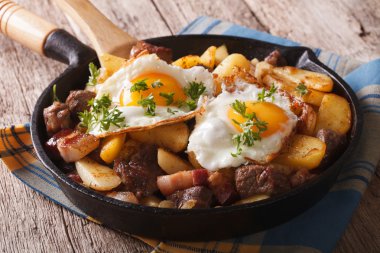 Tyrolean fried potatoes with meat, bacon and eggs in a pan. hori