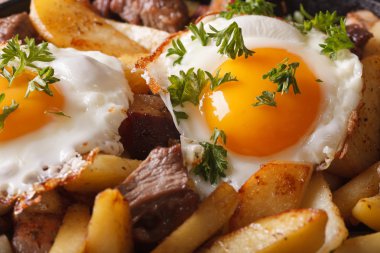 fried potatoes with meat, bacon and eggs macro. horizontal backg