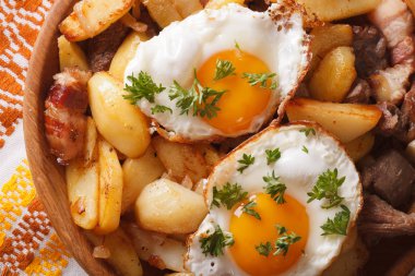 fried potatoes with meat, bacon and eggs close-up horizontal to