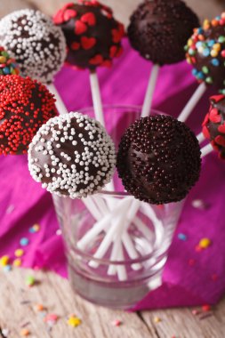Beautiful chocolate cake pops close up in a glass. Vertical