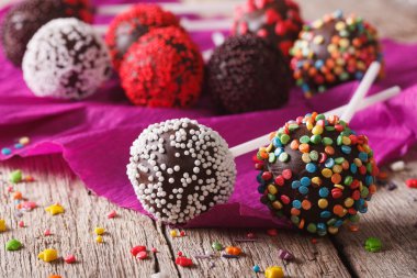 Festive chocolate cake pops with candy sprinkles close-up. horiz