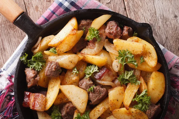 Batatas fritas com carne e bacon em um close-up de panela. Horizontal — Fotografia de Stock