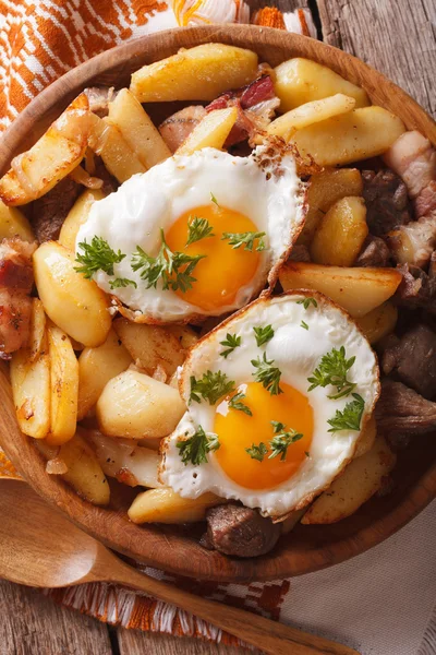 Жареный картофель с мясом, беконом и яйцами крупным планом — стоковое фото