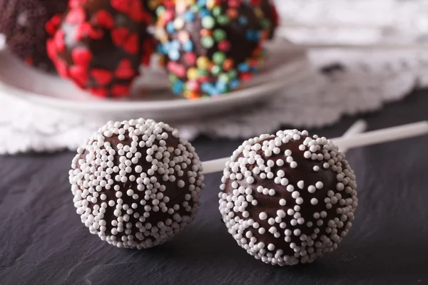 Two chocolate cake pops with white candy sprinkles close-up. hor — Stock Photo, Image