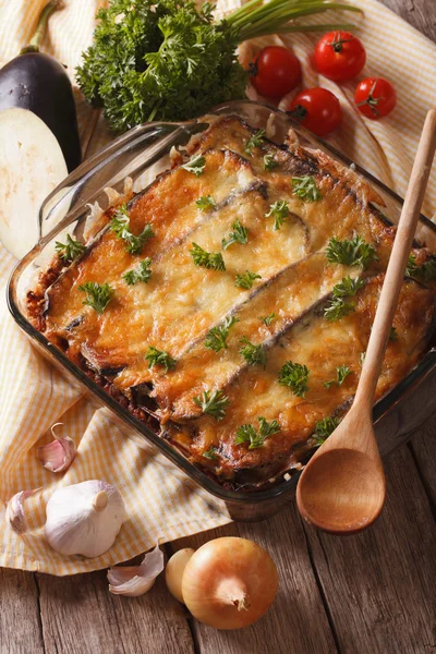 Moussaka grecque en gros plan dans le plat de cuisson et les ingrédients. vertical — Photo