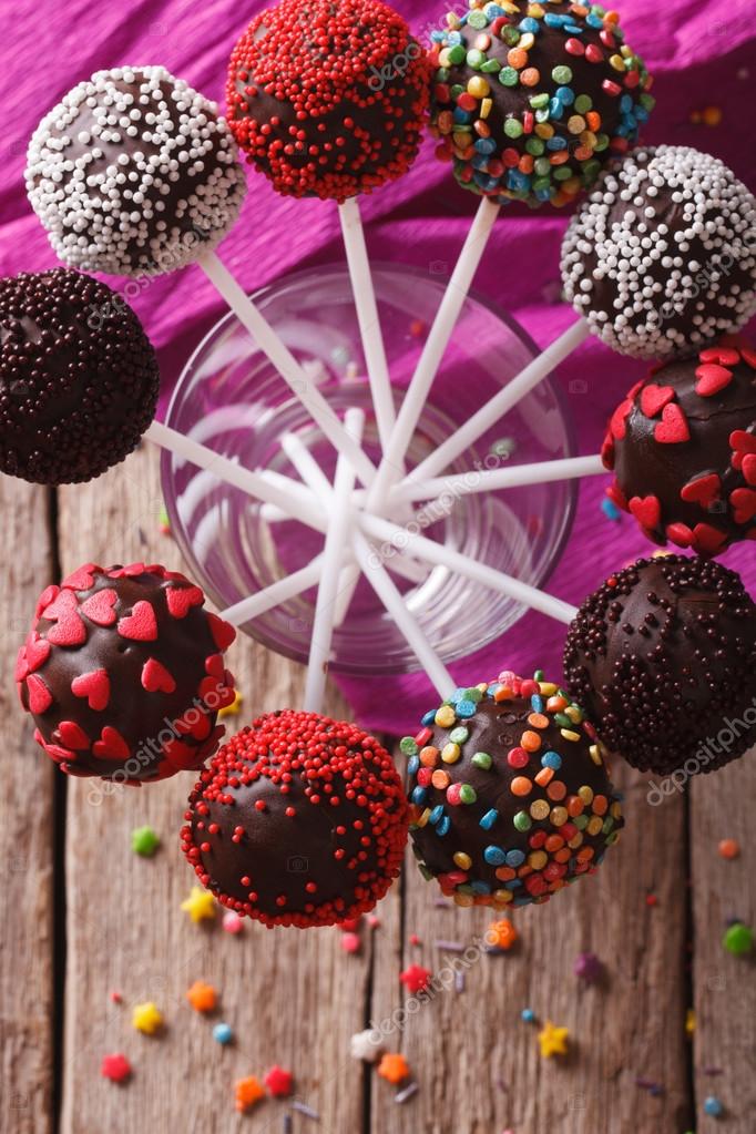 Delicious colorful cake pops in a glass closeup. vertical