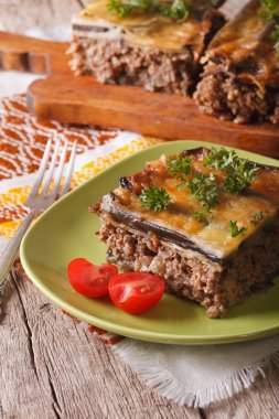Portion of moussaka with eggplant on a plate close-up. Vertical