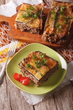 Portion of moussaka with eggplant on a plate close-up. Vertical 