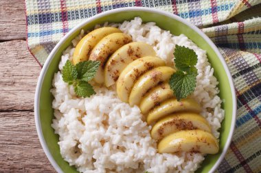 Rice with caramelized apples in a bowl close-up. Horizontal top 