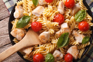fusilli pasta with chicken and tomatoes closeup. horizontal top 