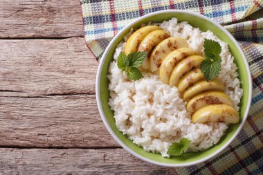 Rice with caramelized apples in a bowl. Horizontal top view