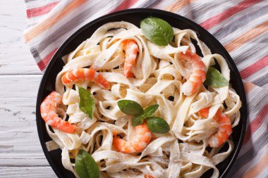 fettuccini pasta in cream sauce with shrimp close-up. horizontal