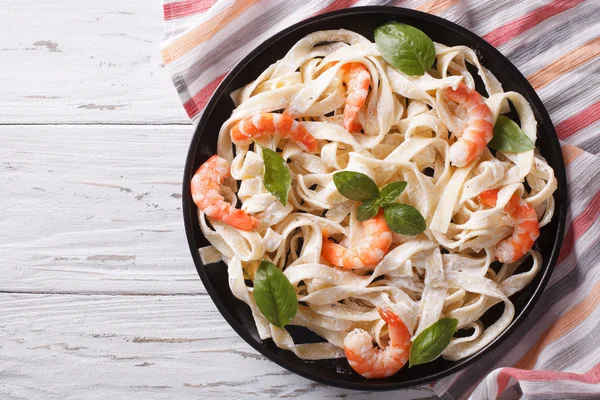 Fettuccini pasta in cream sauce with shrimp. horizontal top view — Stok fotoğraf