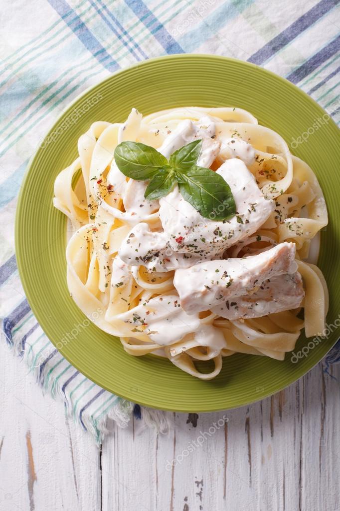 alfredo pasta in cream sauce with chicken closeup. vertical top 