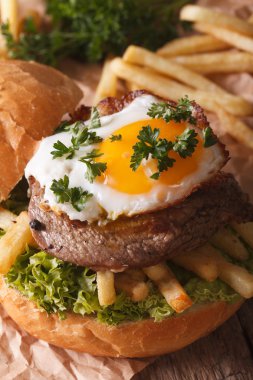 Biftek, kızarmış yumurta ve patates kızartması yakın çekim ile sandviç. vertic