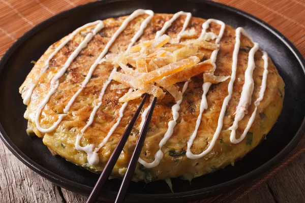 Japanese fast food: okonomiyaki close-up and chopsticks. horizon — Stock Photo, Image