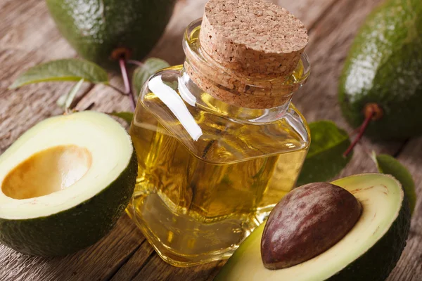 Здоровое масло авокадо в стеклянной бутылке на столе крупным планом. Хориз — стоковое фото